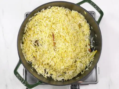 frying rice to make turmeric rice