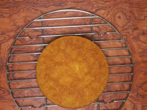 cooling eggless orange cake on a rack