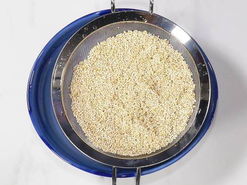 draining quinoa in a colander to make pulao