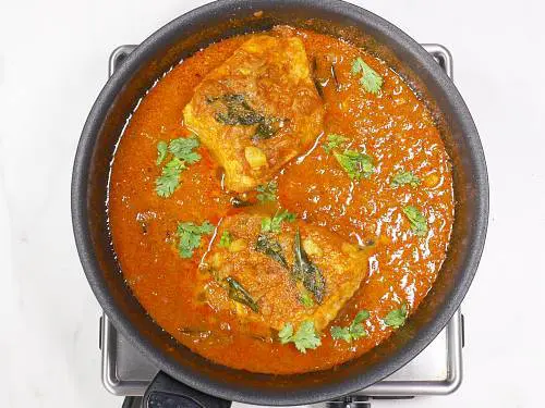 garnishing salmon curry with coriander leaves