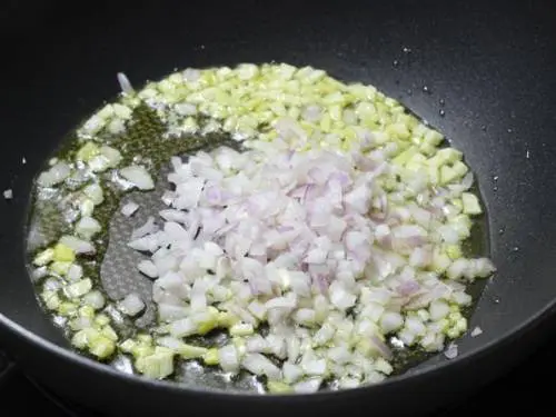 frying ginger garlic and onions in a pan