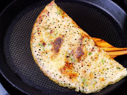 crisp fried rava dosa on a non stick pan