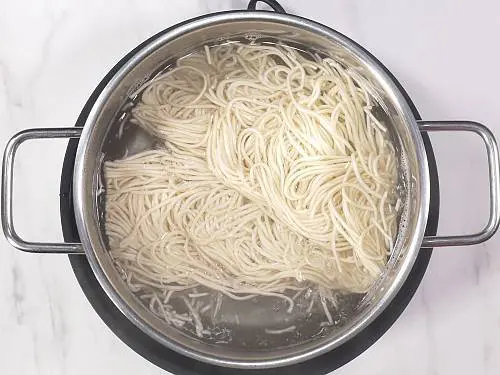 boiling hakka noodles in a pot