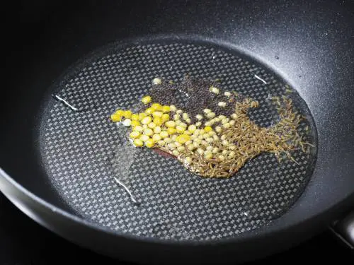 tempering mustard cumin in a pan