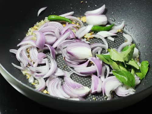 frying onions in oil to make majjiga pulusu
