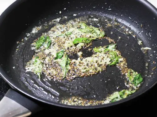 tempering spices to make sweet potato stir fry