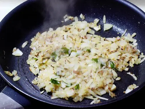 stir frying onions to make sweet potato stir fry.