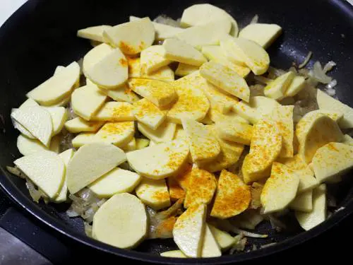 adding turmeric over sweet potatoes