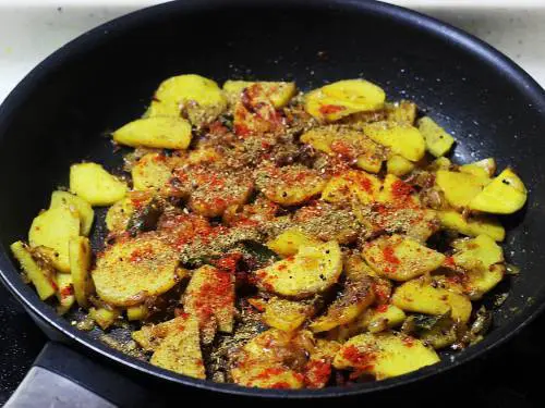 adding spice powders to make sweet potato stir fry