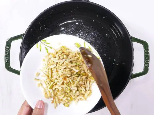 transferring fried nuts seeds to a plate