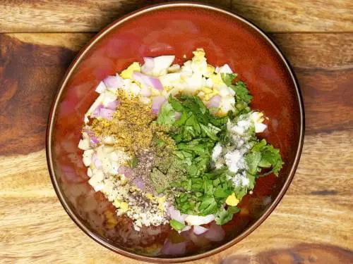 adding herbs garlic and mustard to eggs