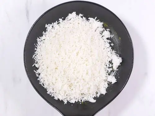 adding cooled rice and lemon juice to the pan