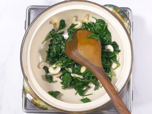 wilted spinach in a white clay pot