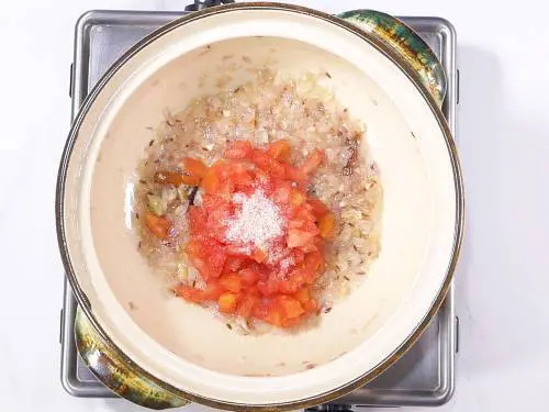 sauteing tomatoes with salt to make palak paneer