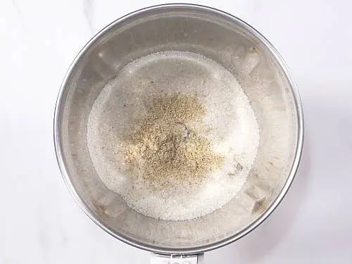 sugar and cardamoms in a grinder jar