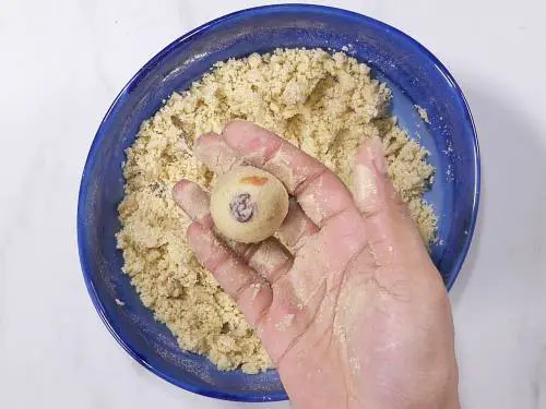 pressing down the mixture to make rava ladoo