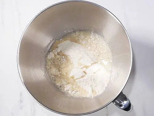 adding flour water oil to bowl to make dough
