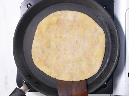cooking stuffed paratha on a pan