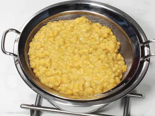 straining dal in a colander