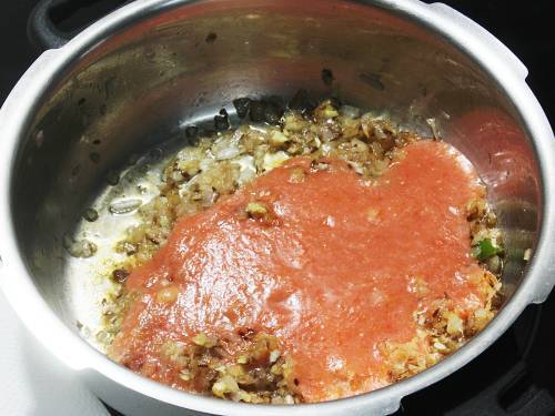 adding tomato puree to make kala chana