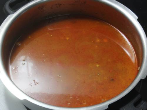 pouring water to make kala chana in cooker