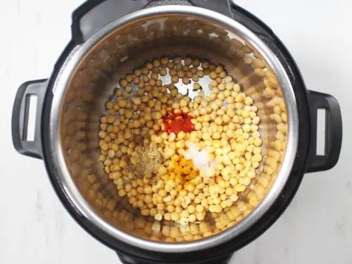 adding peas to cooker to make ragda