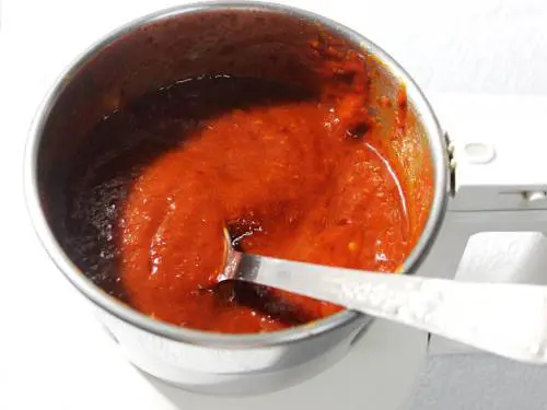 blending red garlic chutney in a grinder jar