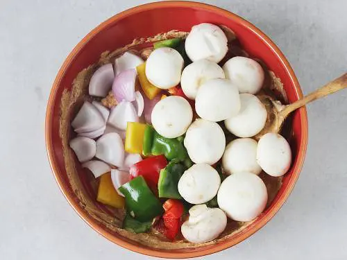 adding veggies to marinade