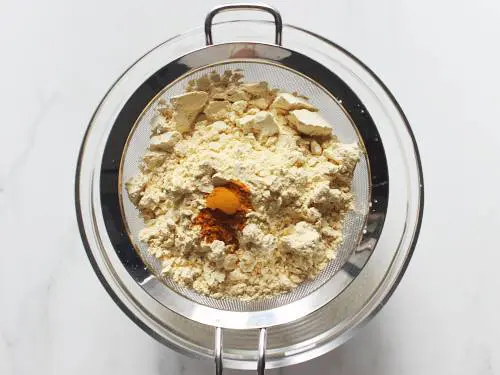 sieve besan and turmeric to make dhokla