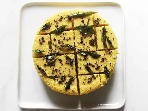 pour tempering over steamed khaman dhokla