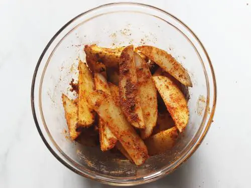 spiced potato wedges ready to go inside the oven