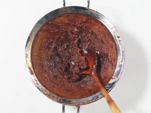 passing chutney through a strainer