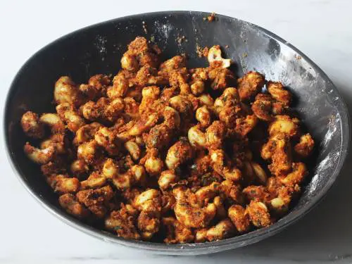 cashews coated with masala ready to roast in oven