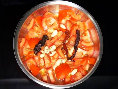 boiling tomatoes spices and cashews to make paneer lababdar