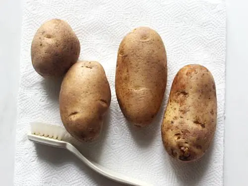 brushing potatoes to make wedges