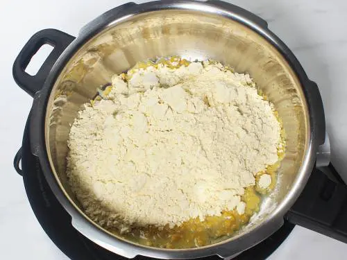 adding besan to ghee for roasting