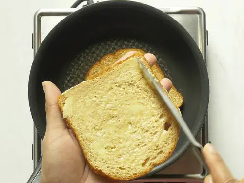 smear butter over bread to make croutons for tomato soup