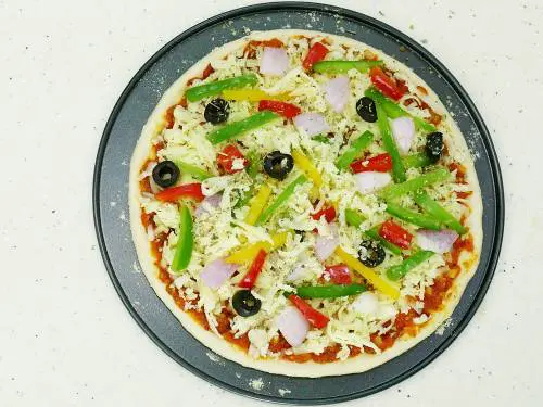 layer veggies, cheese and herbs on the pizza base