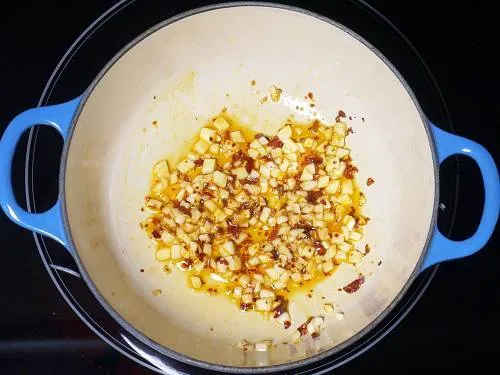 frying garlic in oil to make pizza sauce