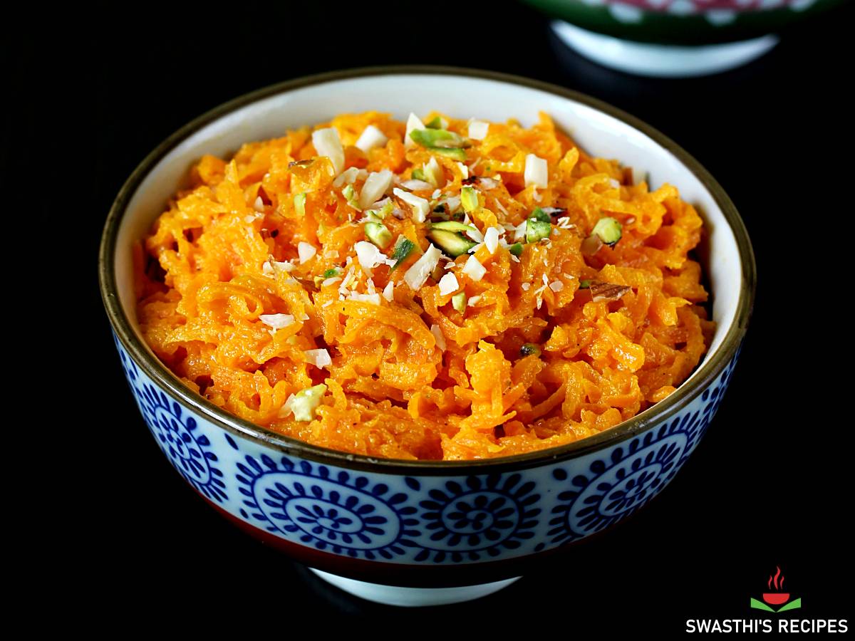 gajar ka halwa in a blue bowl garnished with chopped nuts