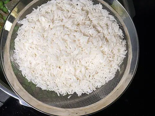 drain soaked rice to colander for peas pulao