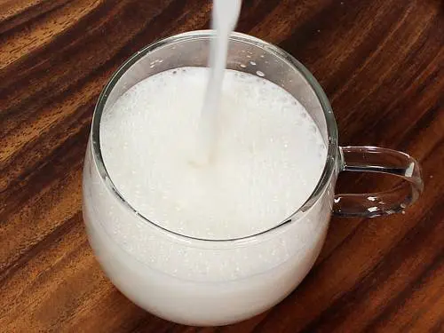 frothy almond milk in a cup