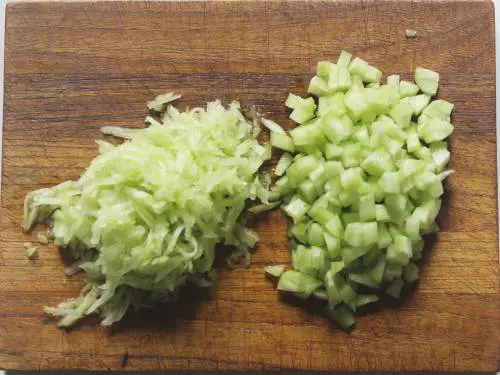 chopped and grated cucumbers on chopping board for raita