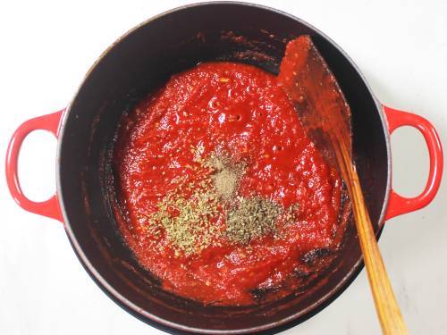 adding herbs to pizza sauce