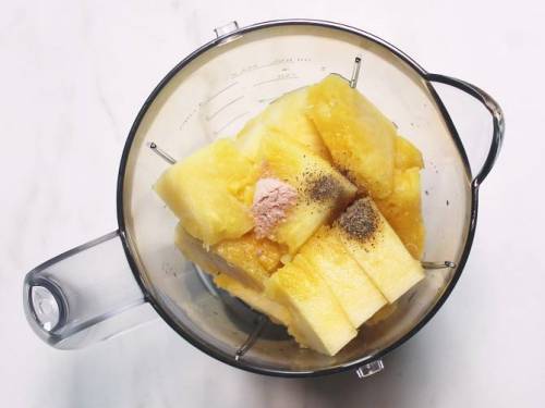 adding pineapple salt spices to a blender to juice
