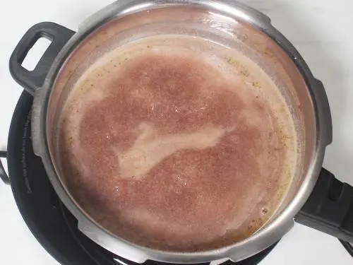 thick ragi mixture boiling in a pot for mudde