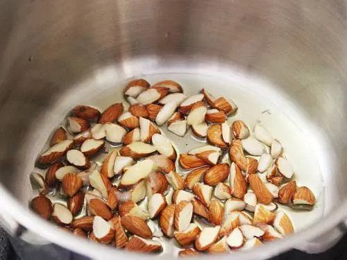 frying nuts in ghee to make papaya halwa