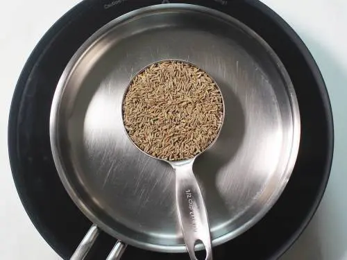 cumin seeds in a measuring cup