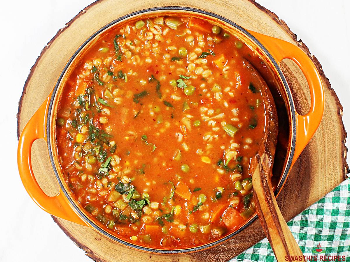 vegetable barley soup garnished with coriander leaves