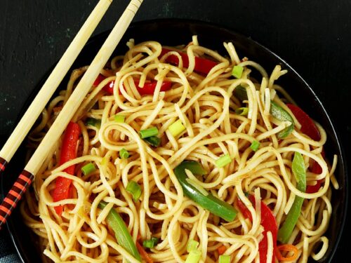 hakka noodles served in a black plate